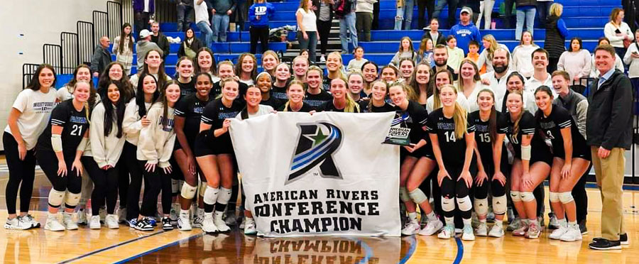 Volleyball Team holding a banner saying Conference Champions